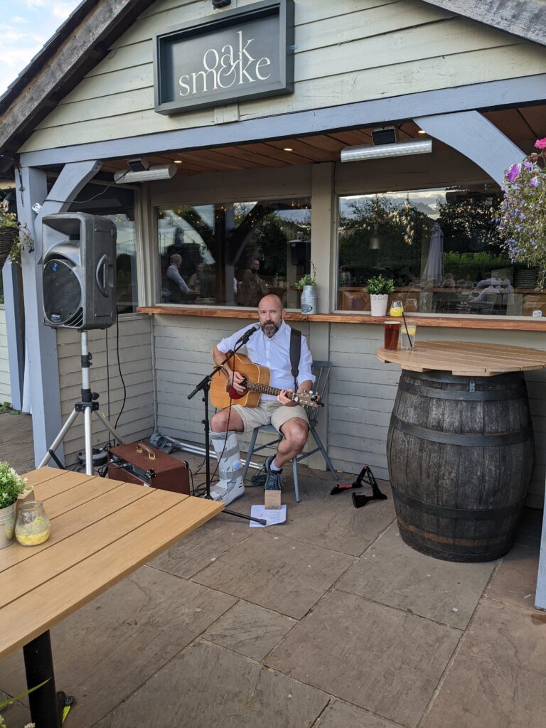 Me playing at a wedding outdoors at The Chester Fields pub, my broken leg still in a supportive boot!